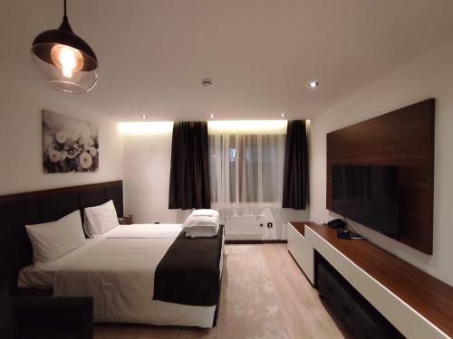 a bedroom with a bed and a flat screen tv at Zoned II Kopaonik - Studio Njegomir in Kopaonik