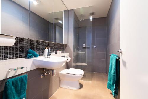 ein Badezimmer mit einem weißen WC und einem Waschbecken in der Unterkunft Experience Port Melbourne in Melbourne