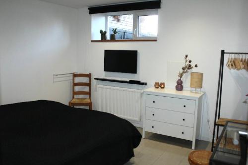 a bedroom with a bed and a tv on a wall at Lothani Luxury Inn in Aalborg