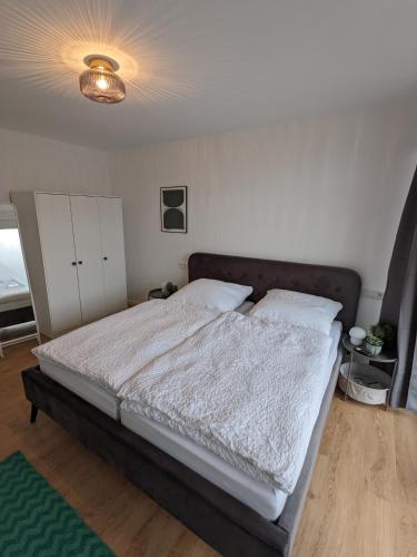 a bedroom with a large bed with white sheets at Zentrale und gemütliche Ferienwohnung in Winterberg nah an der Natur in Winterberg