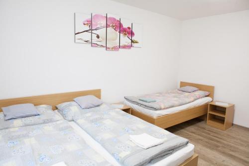 a bedroom with two beds and a picture on the wall at Lidový dům Halenkov in Halenkov