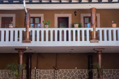 a house with a white railing and a balcony at Casa Graciela Hotel Pátzcuaro in Pátzcuaro