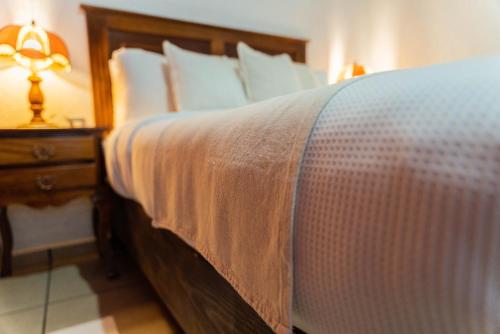 a bedroom with a bed and a night stand with a lamp at Casa Graciela Hotel Pátzcuaro in Pátzcuaro