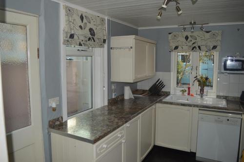 a kitchen with white cabinets and a sink at The Crandale House Vacation Home in Bath