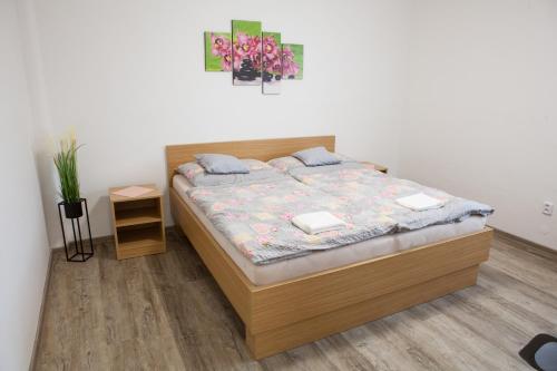 ein Schlafzimmer mit einem Bett mit einem Bettrahmen aus Holz in der Unterkunft Lidový dům Halenkov in Halenkov
