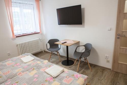 Zimmer mit 2 Betten, einem Tisch und einem TV in der Unterkunft Lidový dům Halenkov in Halenkov