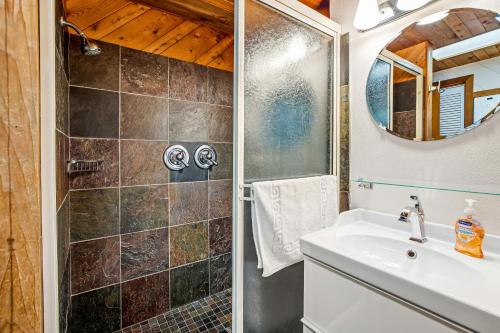 a bathroom with a shower and a sink at Blue Sea Oceanfront Cottage in Oceanside