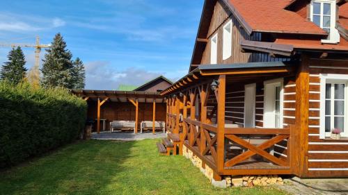 ein Haus mit einem Holzzaun neben einem Hof in der Unterkunft Chajda Harrachov in Harrachov