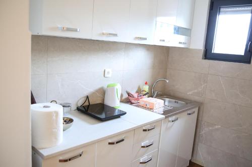 a kitchen with a sink and a counter top at Aria Apartmani in Podgorica