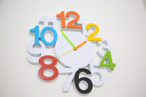 a clock with different numbers on a white background at Aria Apartmani in Podgorica