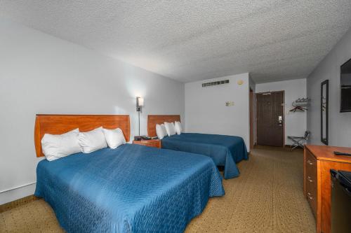 a hotel room with two beds and a television at The Dakota in Sioux Falls