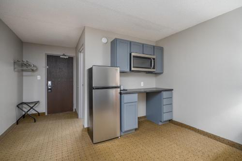 a kitchen with a refrigerator and a microwave at The Dakota in Sioux Falls