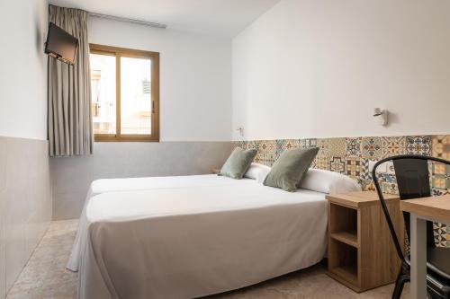מיטה או מיטות בחדר ב-Hostal Baler
