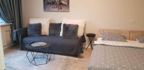 uma sala de estar com um sofá e uma cama em "Vingio"-Apartment em Klaipėda