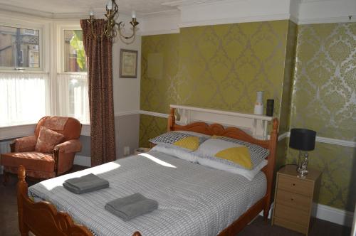 a bedroom with a bed and a chair at The Crandale House Vacation Home in Bath