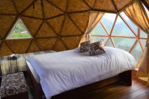 a bed in a yurt with a large window at Aldebarán Farming & Glamping in Duitama