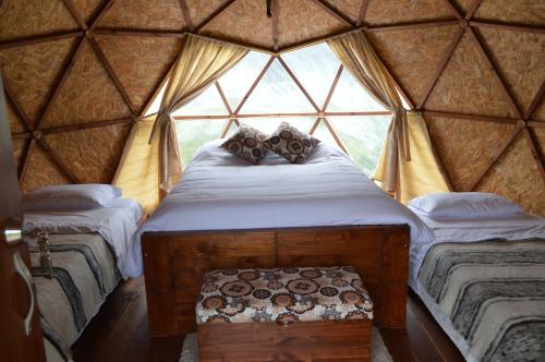 a bed in a yurt with a window at Aldebarán Boyacá in Duitama
