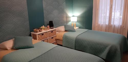 2 łóżka w pokoju z zielonymi ścianami w obiekcie Chambres d'hôtes Nilautpala Dreams w mieście Saint-Jean-de-Maurienne