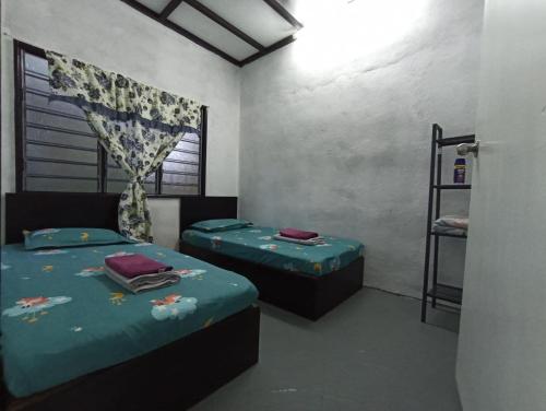 Habitación con 2 camas y ventana en HOME2STAY CHE MAIL 2 KUALA ROMPIN, en Kampong Perpat