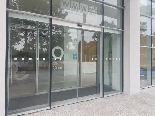 a glass door of a building with a sign on it at Ocean Drive Country - Punta del Este in Punta del Este