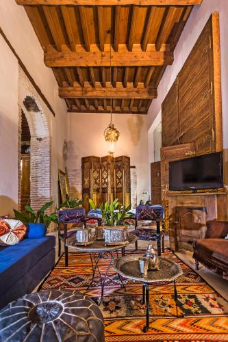 a living room with a couch and tables and a fireplace at Casa Palacio Rincón de la Catedral in Toledo
