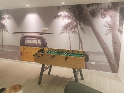 a pool table in a room with palm trees at Ocean Drive Country - Punta del Este in Punta del Este