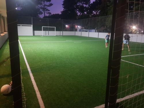 two people playing soccer on a tennis court at night at Ocean Drive Country - Punta del Este in Punta del Este
