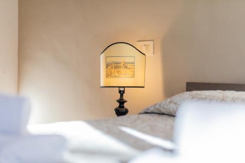 a lamp sitting next to a bed in a room at Firenze Rentals Ponte Vecchio Flat in Florence