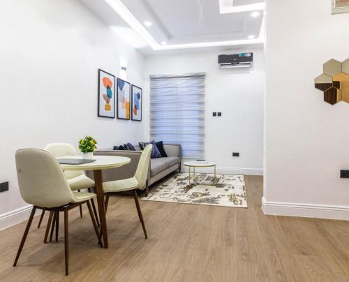 a living room with a table and chairs and a couch at Oslo Apartment in Abuja
