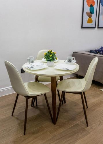 a table with two chairs and a table with flowers on it at Oslo Apartment in Abuja