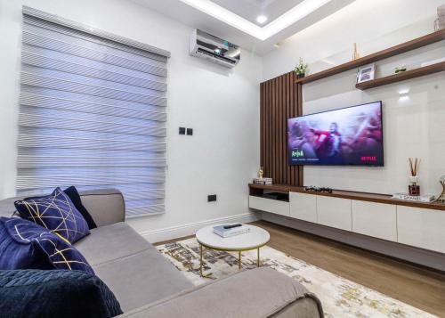 ein Wohnzimmer mit Couch und Flachbildfernseher in der Unterkunft Oslo Apartment in Abuja