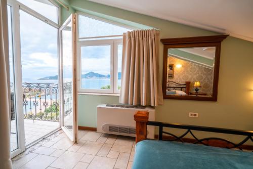 a bedroom with a large window and a view of the ocean at Villa Edelweiss in Sveti Stefan