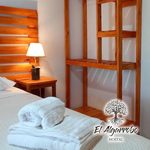 a bedroom with a bed with a wooden ladder at Hostal El Algarrobo in Casa Grande
