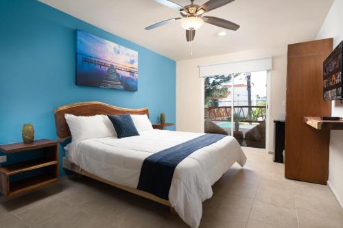a bedroom with a bed with a blue wall at Villa Sofía Holiday Accommodation in Cancún