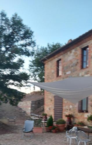 a white umbrella in front of a brick building at Molino della Tuoma in San Quirico dʼOrcia