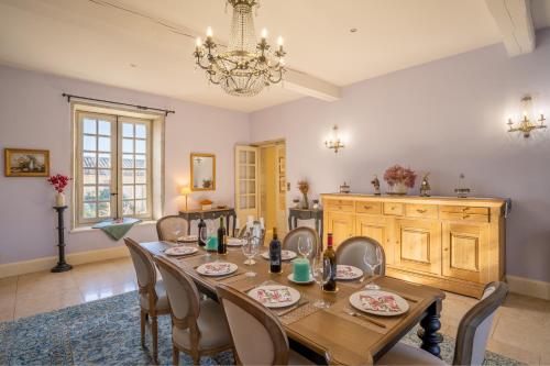 a dining room with a table and chairs and a chandelier at Les Cazettes in Damiatte