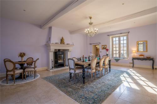 a dining room with a table and chairs and a fireplace at Les Cazettes in Damiatte