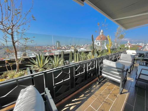 d'un balcon avec des chaises et une vue sur la ville. dans l'établissement Hotel Tamara, à Puebla