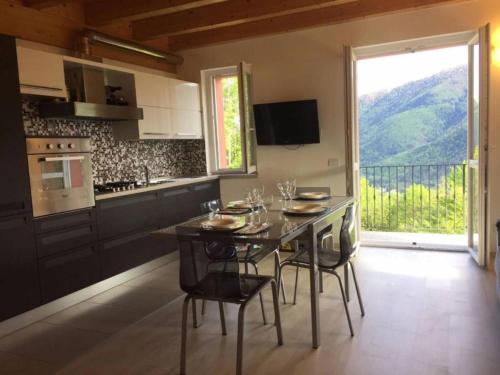 een keuken met een tafel en stoelen en een groot raam bij Casa Vista Monte Rosa in Toceno