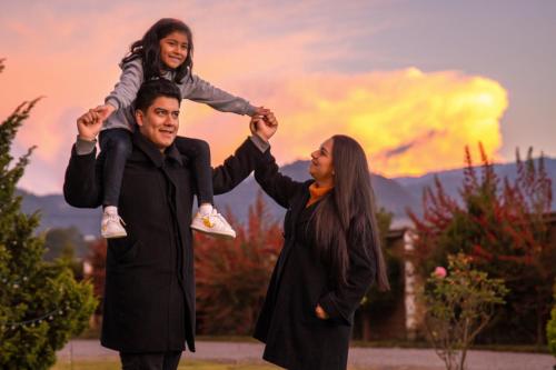 a man and a woman holding a little girl on their shoulders at Hacienda Grande Hotel in Quetzaltenango