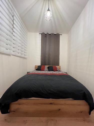 une chambre avec un grand lit avec une fenêtre dans l'établissement VANNES INTRA MUROS T2 LES HALLES, à Vannes