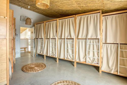a room with a bunch of windows with curtains at Selina Boavista Ericeira in Ericeira
