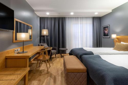 a hotel room with two beds and a desk at Scandic Tampere City in Tampere
