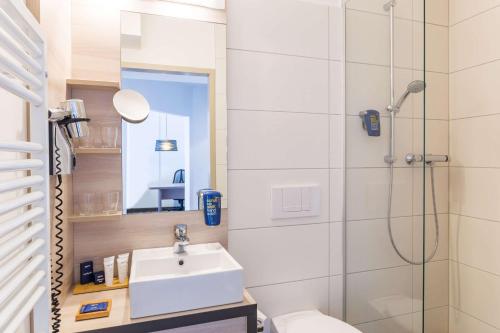 a bathroom with a sink, toilet and shower at Park Inn by Radisson Göttingen in Göttingen