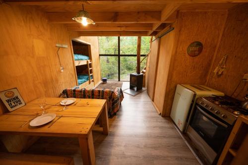 ein kleines Zimmer mit einem Tisch und einem Herd in der Unterkunft Andrómeda Lodge in Las Trancas