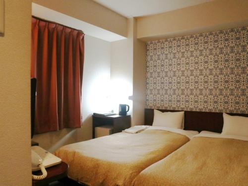 Postel nebo postele na pokoji v ubytování Hamamatsu Station Hotel