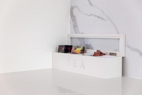 a white shelf with books on it in a room at Lotus Stay Manly - Apartment 31A in Sydney