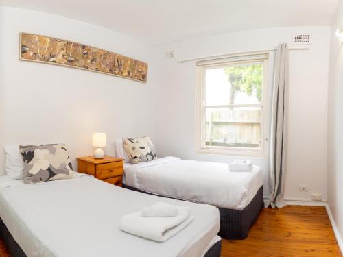 a bedroom with two beds and a window at Lotus Stay Manly - Apartment 31A in Sydney