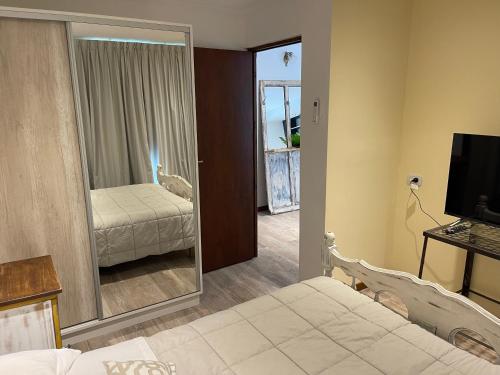 a bedroom with a bed and a television and a mirror at ApartaHotel LaCatedral in Reconquista