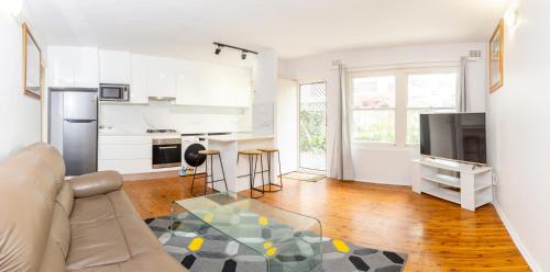 a living room with a couch and a table at Lotus Stay Manly - Apartment 31A in Sydney